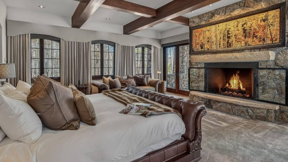 Queen bedroom with a fully lowered dark blackout shade on the right window at Kingdom House