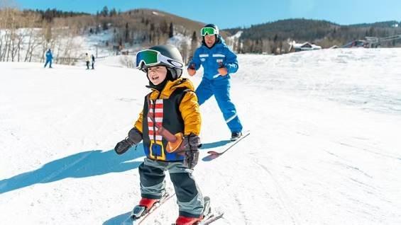 Ski instructor following a child through a snowy learning area at Beaver Creek
