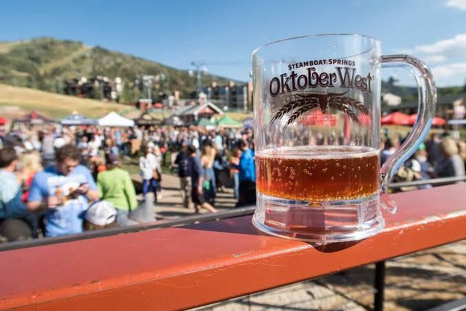 Friends raising craft beer glasses outdoors, representative image for Steamboat OktoberWest